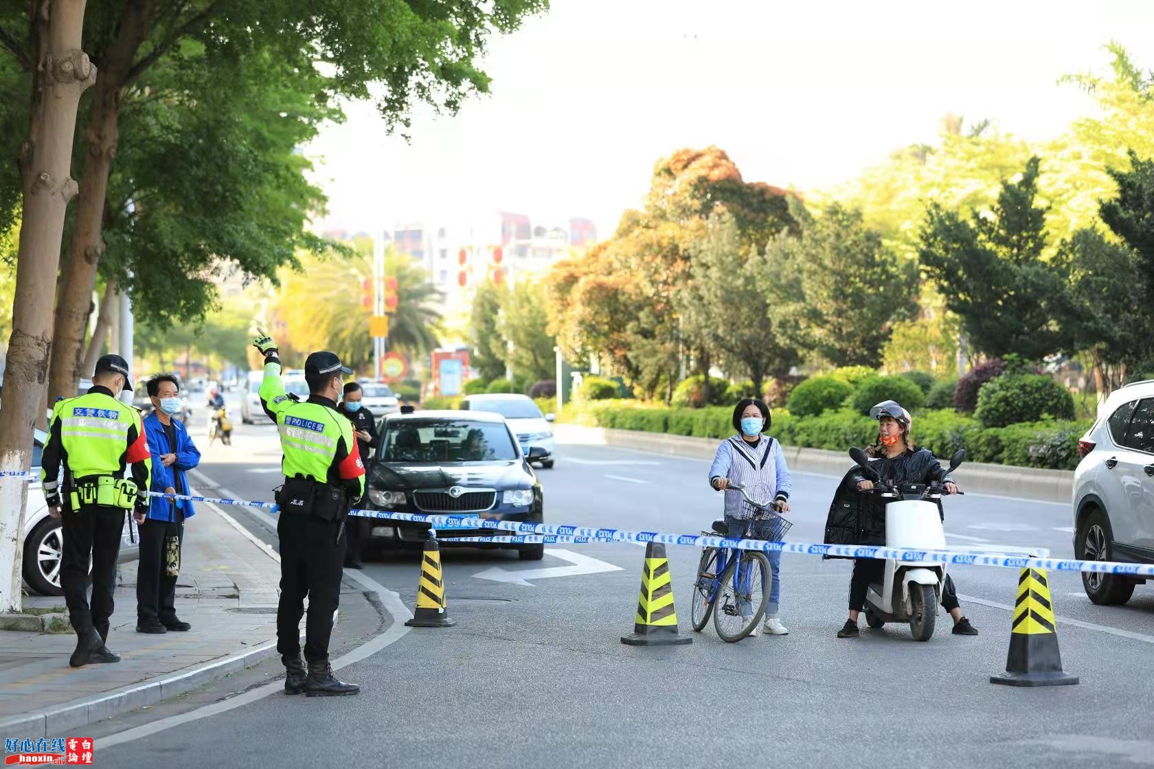 4日下午，电白区政府附近防范区，交警铁骑指引群众绕道而行，并指导他们正确佩戴口罩。.jpg